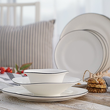 porcelanowy zestaw talerzy z czarną obwódką na stole
