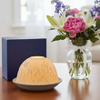 Porcelanowy lampionik na tealight na stole i wazon z kwiatami