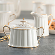 porcelanowa cukierniczka z ażurową przykrywką z kremowej porcelany, dekorowana złotą linią