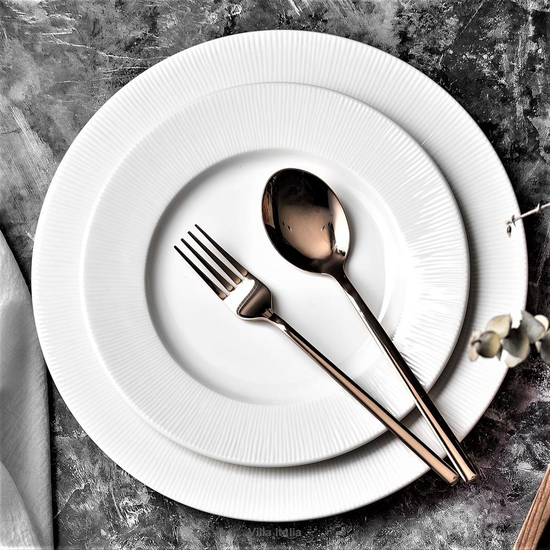 Talerze ceramiczne z gładkim szkliwem i miedziane sztućce