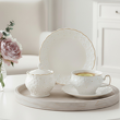 filiżanki do kawy, cukiernica i talerzyk deserowy z białej porcelany dekorowanej złotem