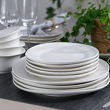 elegancki zestaw talerzy z białej porcelany z nieregularnym kształtem na stole