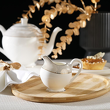 porcelanowy mlecznik z tacą na stole 