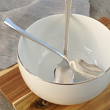 łyżka do sałaty i widelec w salaterce porcelanowej