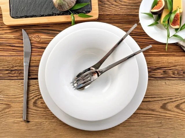 Białe talerze porcelanowe z kolekcji Plus White na nakrytym stole